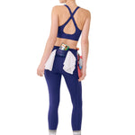 Woman wearing a blue sports bra and leggings with a white background