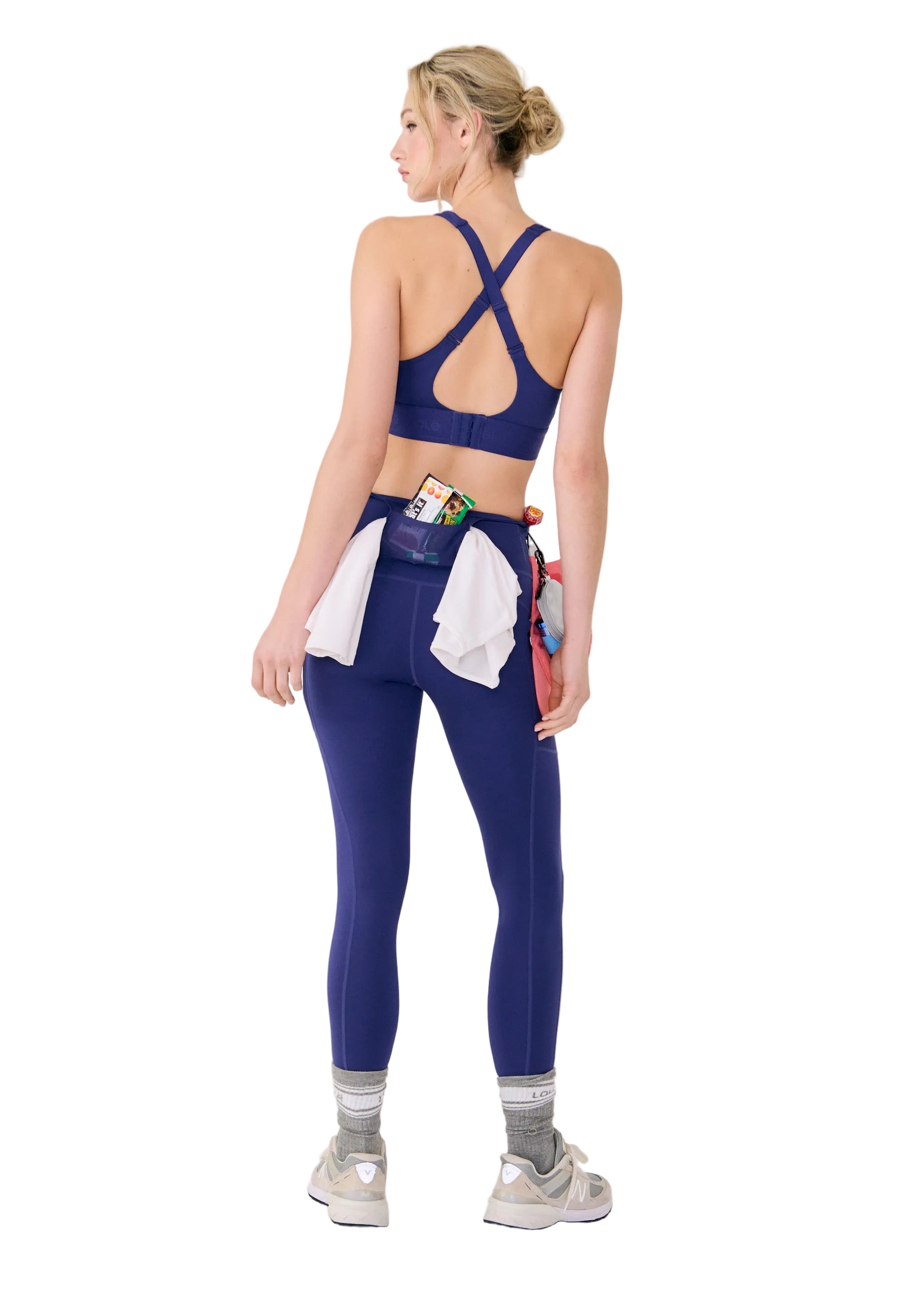 Woman wearing a blue sports bra and leggings with a white background