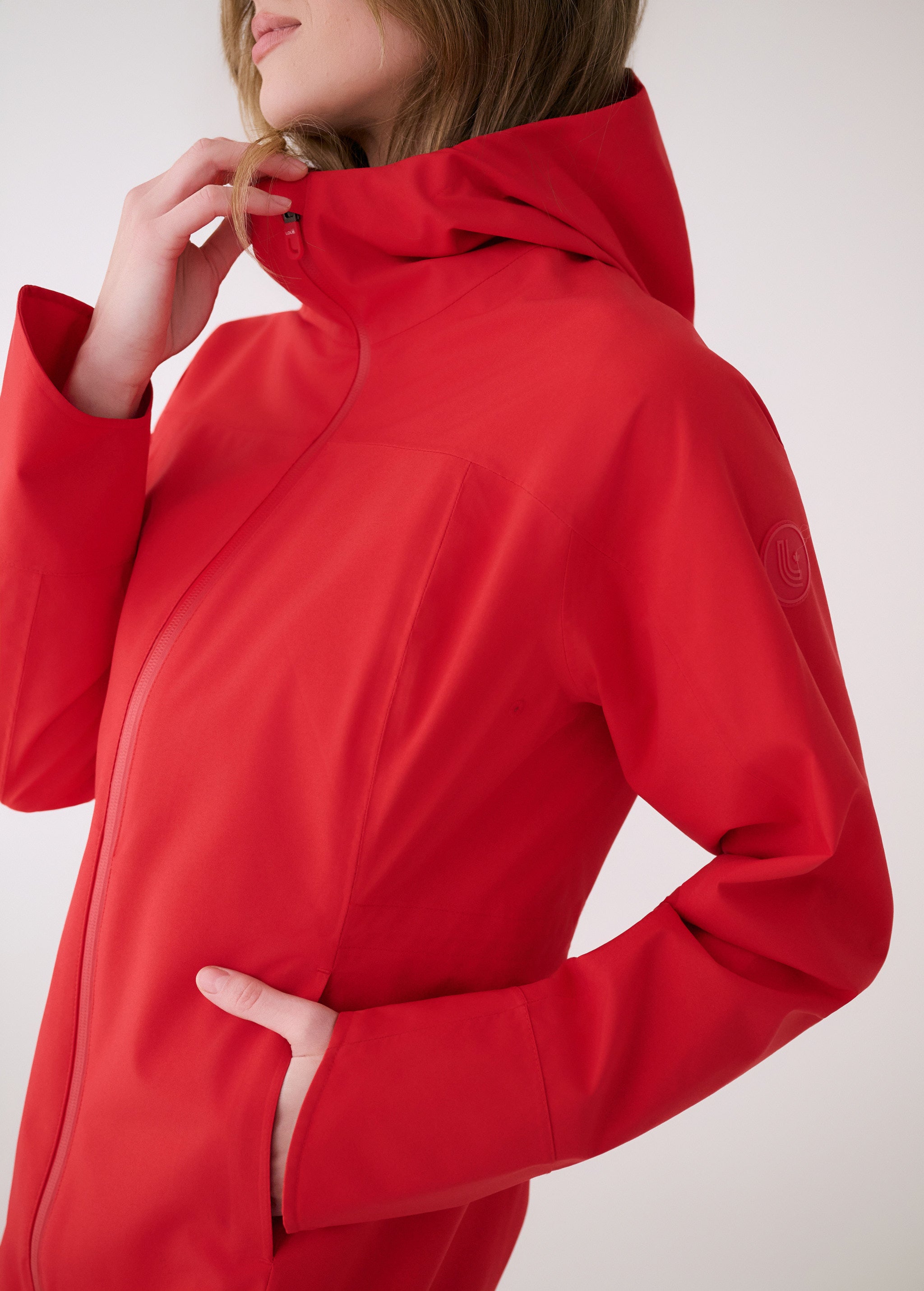 Lolë Element Long Rain Jacket in Poppy red — this longline jacket keeps water out while keeping your look sharp